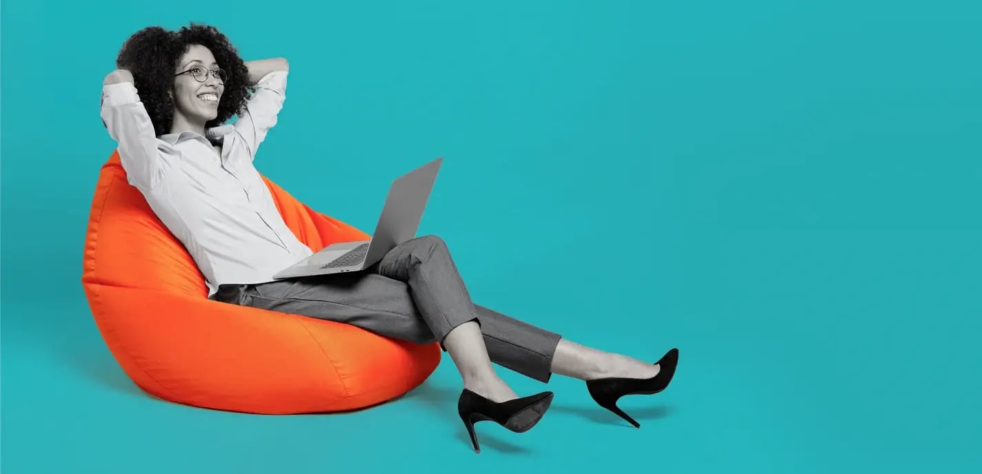 Young female lawyer of African American ethnicity in formal shirt work in office sit in bag chair hold use laptop pc computer isolated on teal background