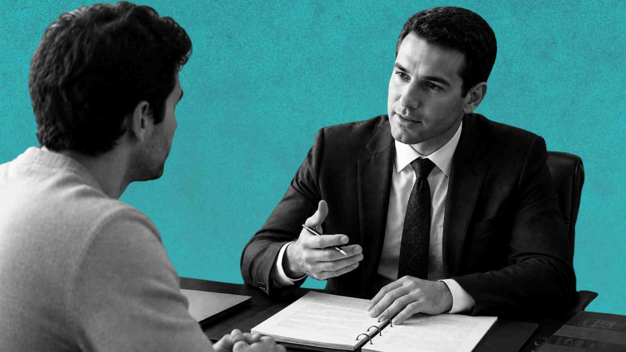 Male attorney sitting across the desk explaining something to his client. 